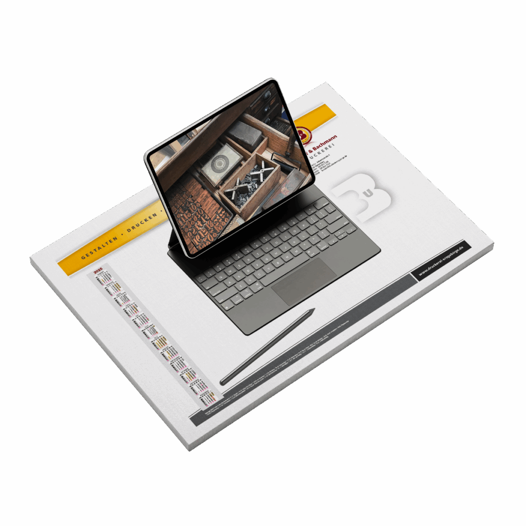 Schreibtischunterlage als Block mit Kalendarium, darauf liegt ein Computer und ein Stift